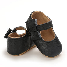 Load image into Gallery viewer, These charming little black bowknot baby shoes are perfect for babies aged newborn to 18 months old. With a choice of colors, they&#39;ll make a delightful addition to any outfit. A soft soled design ensures maximum comfort, while the bow-tie is sure to put a smile on everyone&#39;s face. Upper Material: PU Leather. Outsole Material: Rubber. Closure Type: Hook &amp; Loop.
