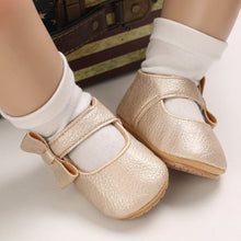 Load image into Gallery viewer, These charming little gold bowknot baby shoes are perfect for babies aged newborn to 18 months old. With a choice of colors, they&#39;ll make a delightful addition to any outfit. A soft soled design ensures maximum comfort, while the bow-tie is sure to put a smile on everyone&#39;s face. Upper Material: PU Leather. Outsole Material: Rubber. Closure Type: Hook &amp; Loop.
