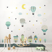 Load image into Gallery viewer, Take your nursery wall to new heights with this whimsical green hot air balloon wall Decal! Featuring a star-filled sky and a moon-lit ride, this fun decal is sure to soar among the stars in your child&#39;s bedroom. So, buckle up and get ready for an adorably adventurous ride! 
