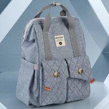 Load image into Gallery viewer, This denim blue diaper backpack, made with fashionable denim blue material, includes stroller straps and a changing pad for added convenience during travel. Perfect for your little baby!
