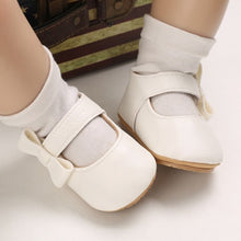 Load image into Gallery viewer, These charming little white bowknot baby shoes are perfect for babies aged newborn to 18 months old. With a choice of colors, they&#39;ll make a delightful addition to any outfit. A soft soled design ensures maximum comfort, while the bow-tie is sure to put a smile on everyone&#39;s face. Upper Material: PU Leather. Outsole Material: Rubber. Closure Type: Hook &amp; Loop.
