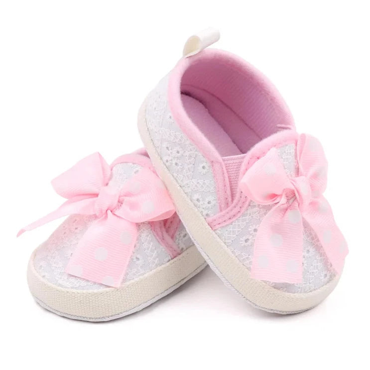 These attractive baby shoes feature a dotted bow design in black, pink and grey. Available in sizes for newborns to 18 months.