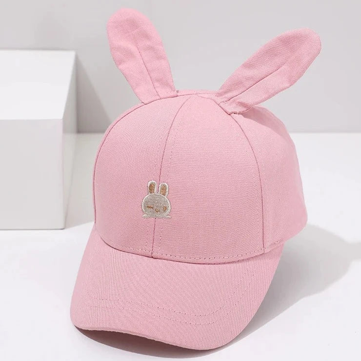 Introducing the adorable Bunny Ears Baseball Hat, available in pink, black, white, and khaki for children newborn to 3 years old! Perfect for adding a touch of cuteness to any outfit.