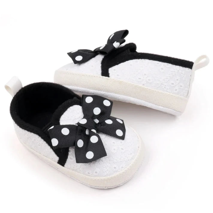 These attractive baby shoes feature a dotted bow design in black, pink and grey. Available in sizes for newborns to 18 months.