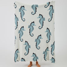 Load image into Gallery viewer, Snuggle up with an ocean of comfort! Our knitted sea horse cotton blanket is perfect for your little mermaid or sailor&#39;s bedroom or nursery. It&#39;s made of Grade A, 100% cotton with a yarn dyed pattern and comes in two cute colors: blue and pink. Yo-ho-ho and a pirate&#39;s hug! Size: 51.18 x 62.99 inches (130cm x 160cm).
