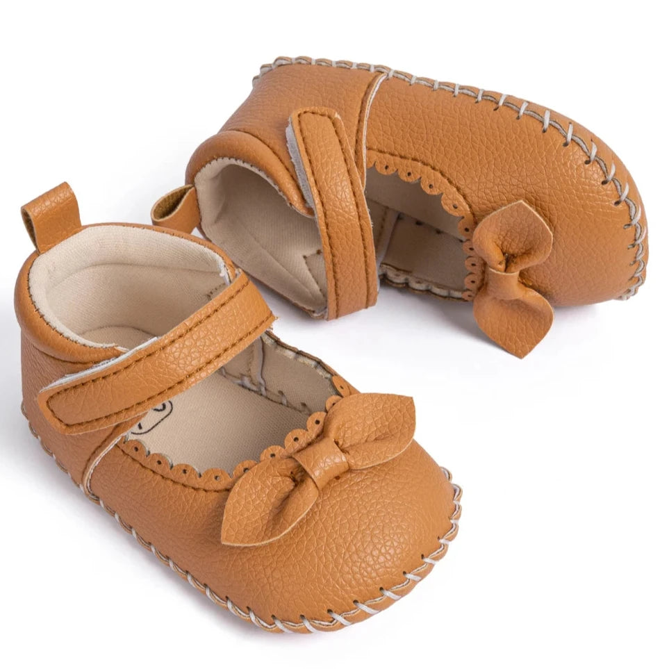 Designed with both style and comfort in mind, these Little Bow-Tie baby shoes are available in a variety of colors and sizes for newborns up to 18 months old. Each pair is meticulously crafted to provide a snug and secure fit for your little princess. Whether you're dressing them up for a special occasion or keeping them comfy for everyday wear, these shoes are the perfect choice for your little one.