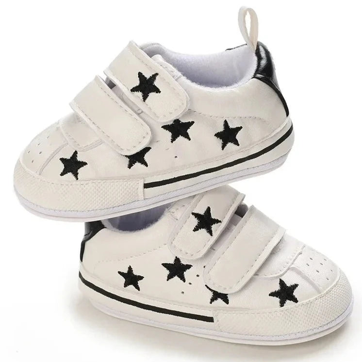 Elevate your little one's style with our Sporty Star Sneakers, designed for newborns to 18 months. These breathable, non-slip shoes feature a crisp white color and sleek black stars, perfect for budding athletes.