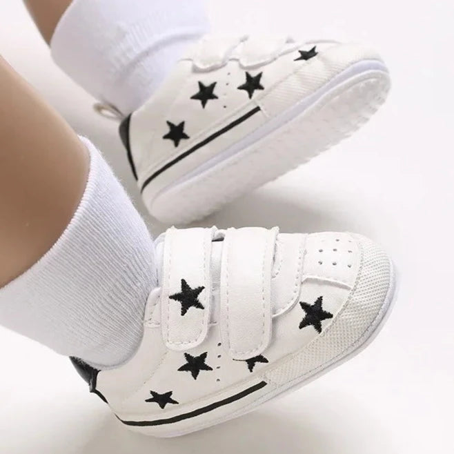 Elevate your little one's style with our Sporty Star Sneakers, designed for newborns to 18 months. These breathable, non-slip shoes feature a crisp white color and sleek black stars, perfect for budding athletes.