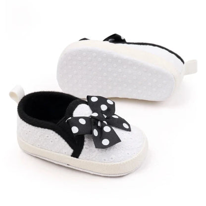 These attractive baby shoes feature a dotted bow design in black, pink and grey. Available in sizes for newborns to 18 months.