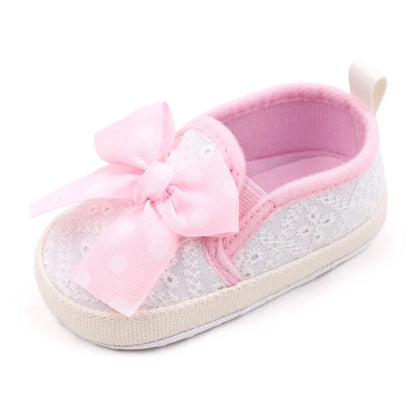 These attractive baby shoes feature a dotted bow design in black, pink and grey. Available in sizes for newborns to 18 months.