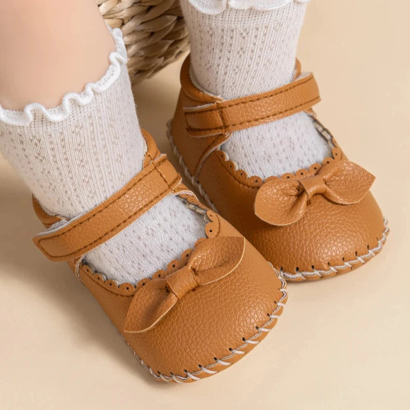 Designed with both style and comfort in mind, these Little Bow-Tie baby shoes are available in a variety of colors and sizes for newborns up to 18 months old. Each pair is meticulously crafted to provide a snug and secure fit for your little princess. Whether you're dressing them up for a special occasion or keeping them comfy for everyday wear, these shoes are the perfect choice for your little one.