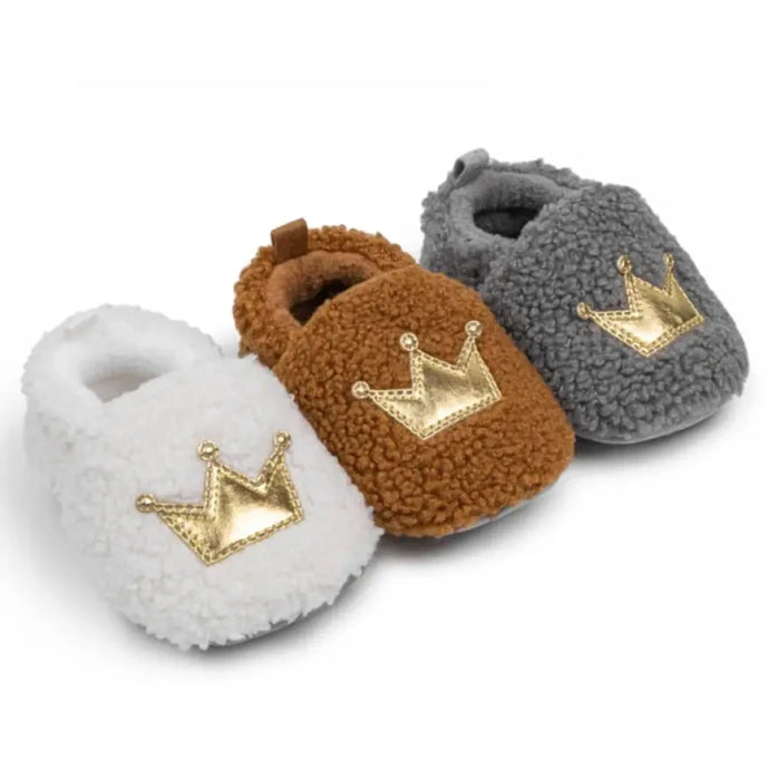 These cozy, snuggly slippers are fit for a royal baby! Made with fluffy teddy bear fabric to keep little toes warm and toasty. Available in sizes for newborns up to 18 months old. Choose from white, grey, or brown.