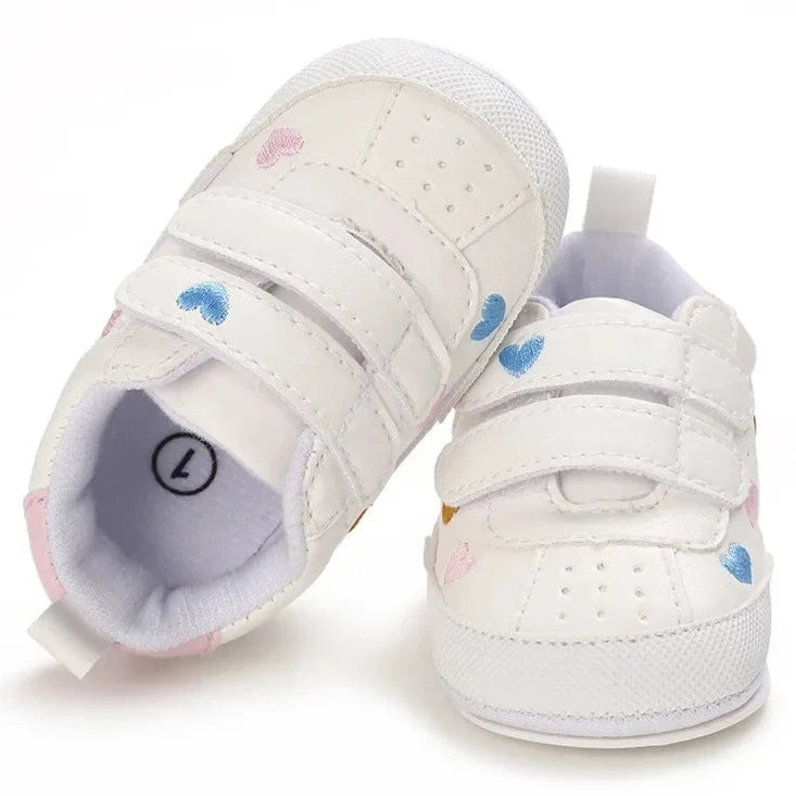 Experience the ultimate in comfort and style with our white embroidered hearts baby sneakers! Adorned with colorful hearts, these sneakers are perfect for babies aged newborn to 18 months. Stay comfortable and steady on your feet with their breathable and non-slip design.