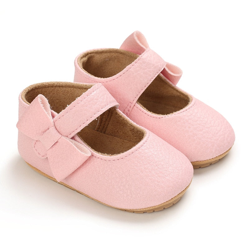 These charming little pink bowknot baby shoes are perfect for babies aged newborn to 18 months old. With a choice of colors, they'll make a delightful addition to any outfit. A soft soled design ensures maximum comfort, while the bow-tie is sure to put a smile on everyone's face. Upper Material: PU Leather. Outsole Material: Rubber. Closure Type: Hook & Loop.