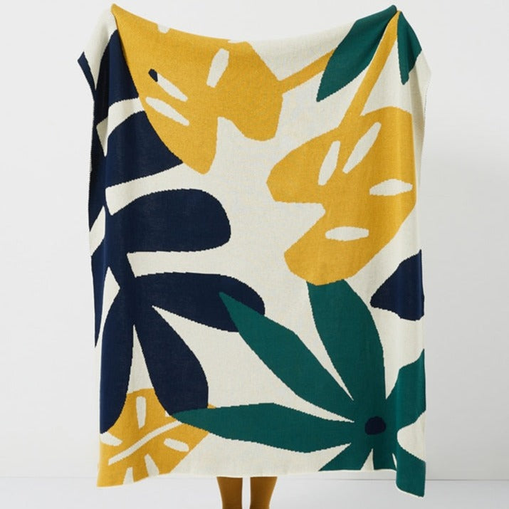 Plant some style in your kid's room with this vibrant knitted blanket! Featuring a lovely array of green, blue and yellow tropical leaves, this decorative throw is perfect for snuggling up in a jungle of cozy comfort.  Size: 51.18 x 62.99 inches (130cm x 160cm) Material: 100% cotton