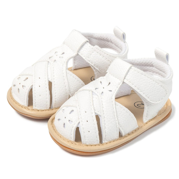 Treat your little one's feet in style with these fun and fashionable baby sandals in white! Perfect for newborns to 18 months, these sandals are available in a variety of colors, so you can pick the right one for any occasion. Style your baby's feet with flair! Upper Material: PU Leather. Outsole Material: Rubber. Feature: Anti-Slip. Closure Type: Hook & Loop. 